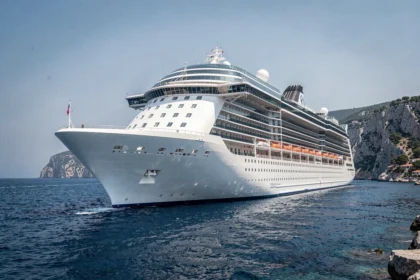 Paquebot de croisière MSC naviguant en Méditerranée avec des falaises côtières en arrière-plan