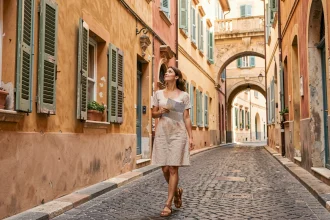 Femme se promenant dans une ruelle pavée du Vieux-Nice entourée de façades colorées en ocre et terracotta